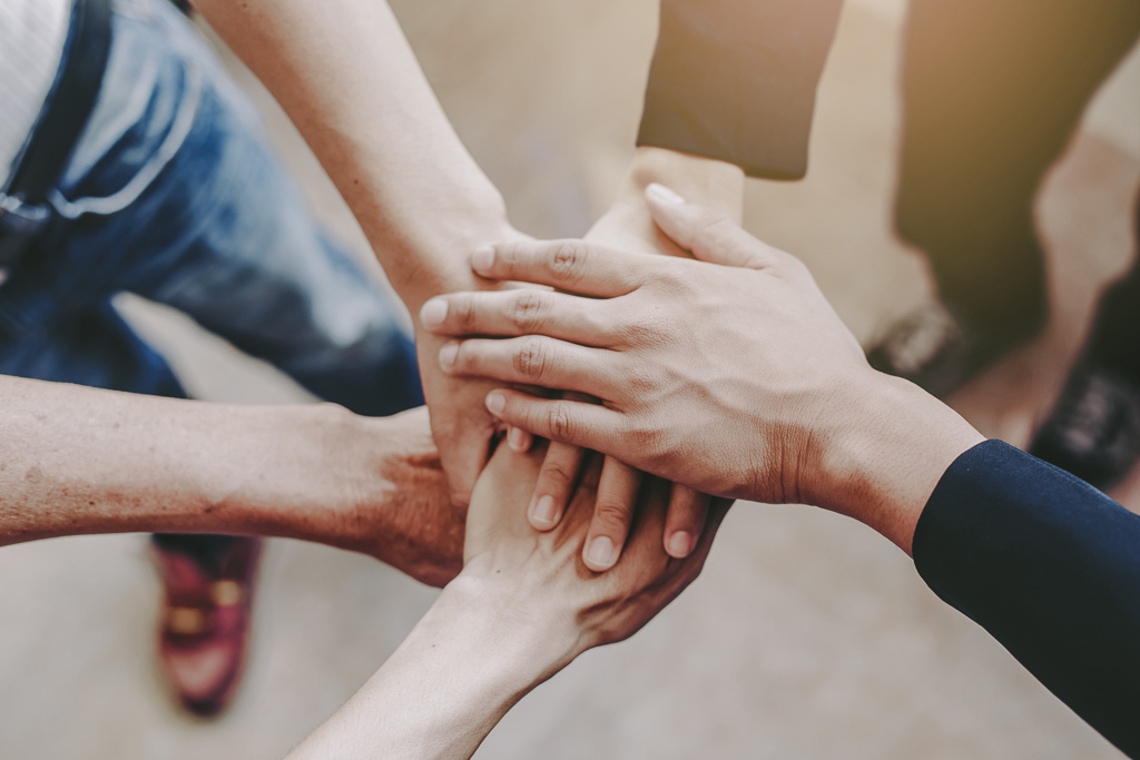 Viele Hände übereinander als Zeichen für Teamwork