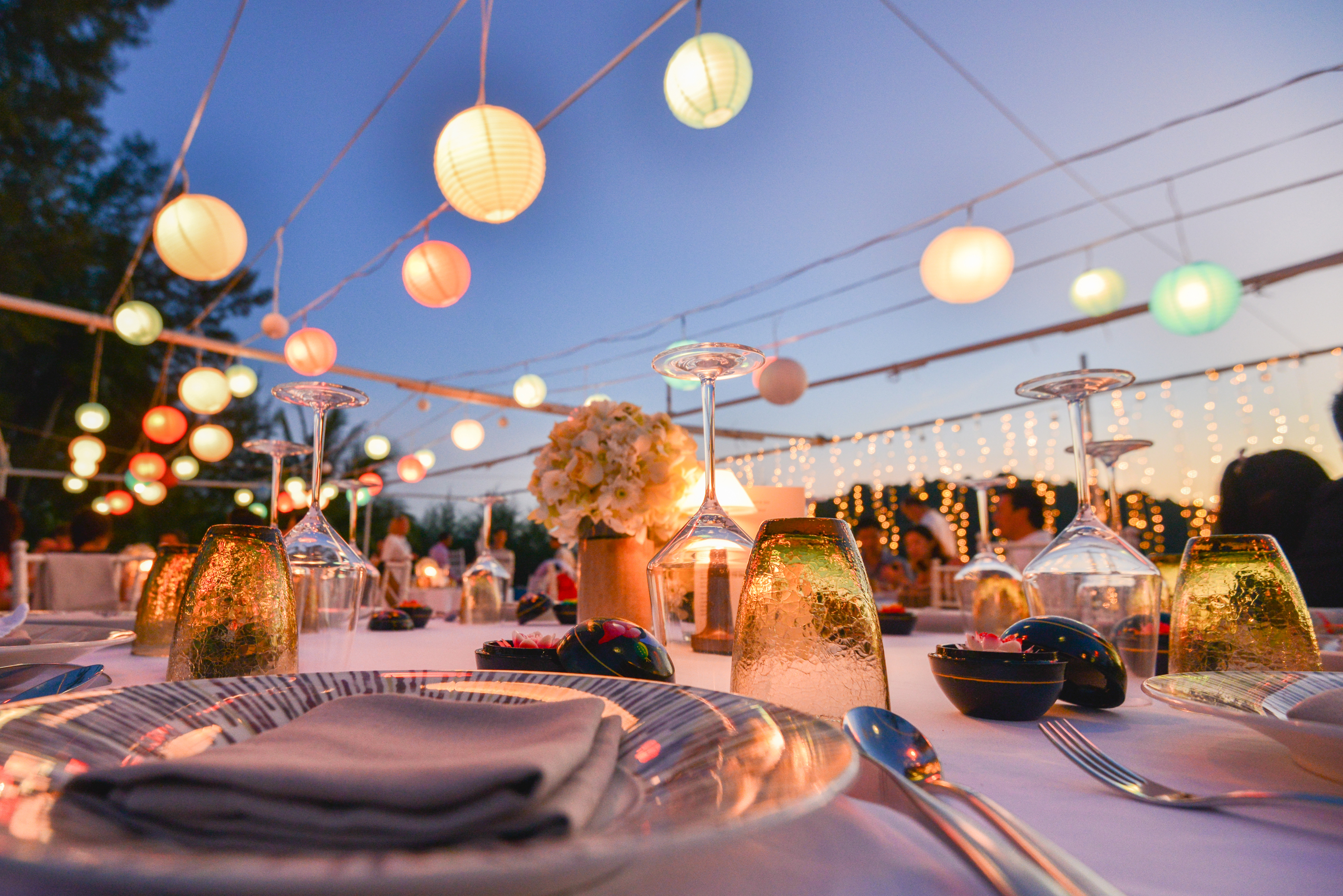 Festlich gedeckte Tafel unter bunten Lampions am Abend